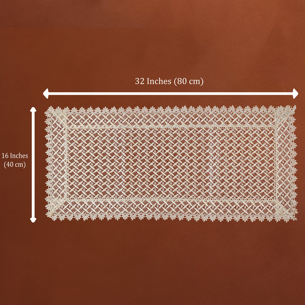 A rectangular cream lace doily with a detailed floral border and openwork center, shown on a brown background with dimension lines indicating 32 inches by 16 inches.