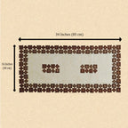 A rectangular patchwork table runner made of many small brown and cream fabric squares, shown on a beige background with measurement arrows labeling it 34 inches by 16 inches.