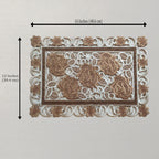 A rectangular placemat with ornate lace-like detailing and raised rose motifs, shown on a light neutral background with dimension arrows indicating 16 inches by 12 inches.