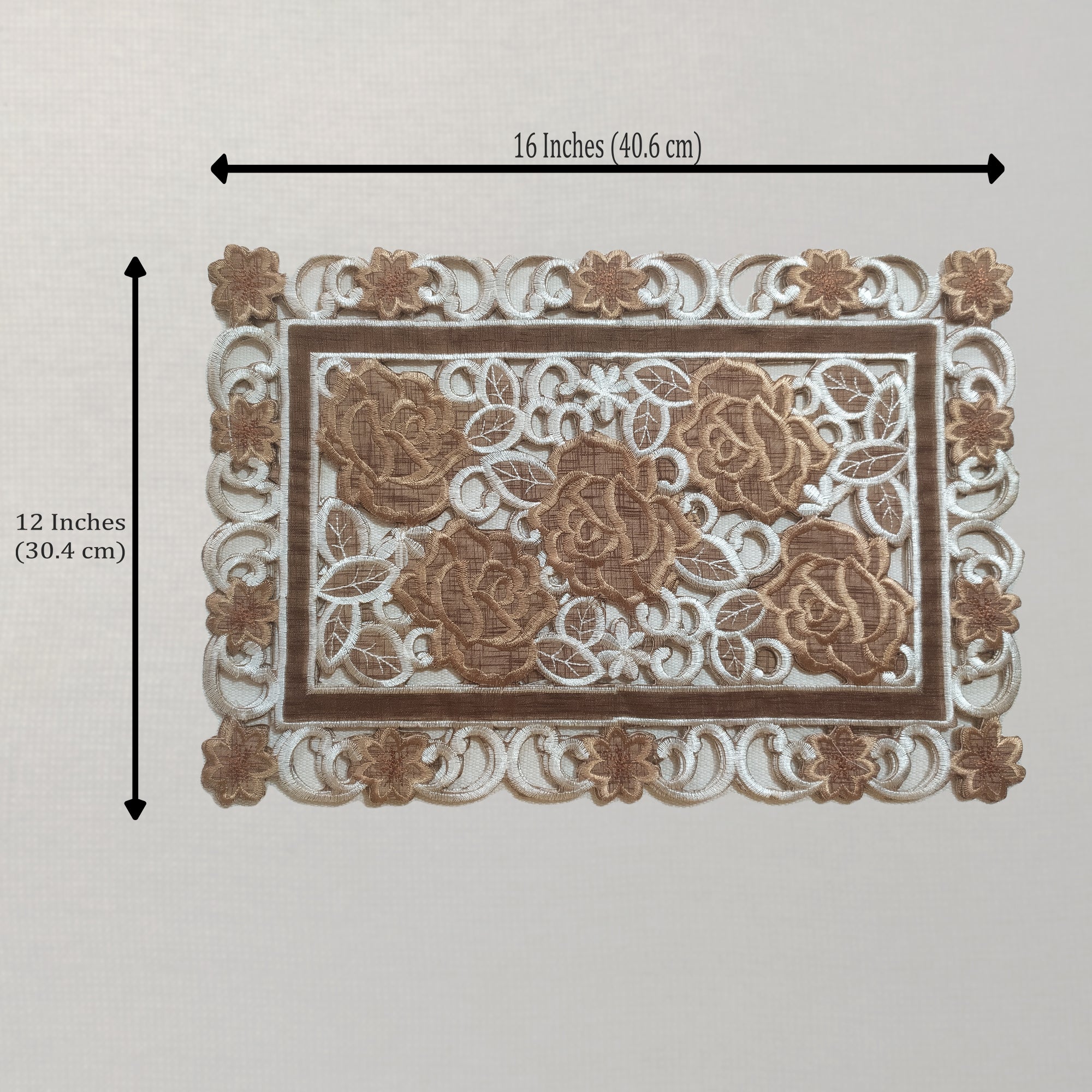 A rectangular placemat with ornate lace-like detailing and raised rose motifs, shown on a light neutral background with dimension arrows indicating 16 inches by 12 inches.