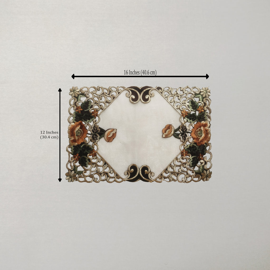 A rectangular placemat with a white center and ornate floral lace-like border, shown on a light neutral background with dimension arrows indicating 16 inches by 12 inches.