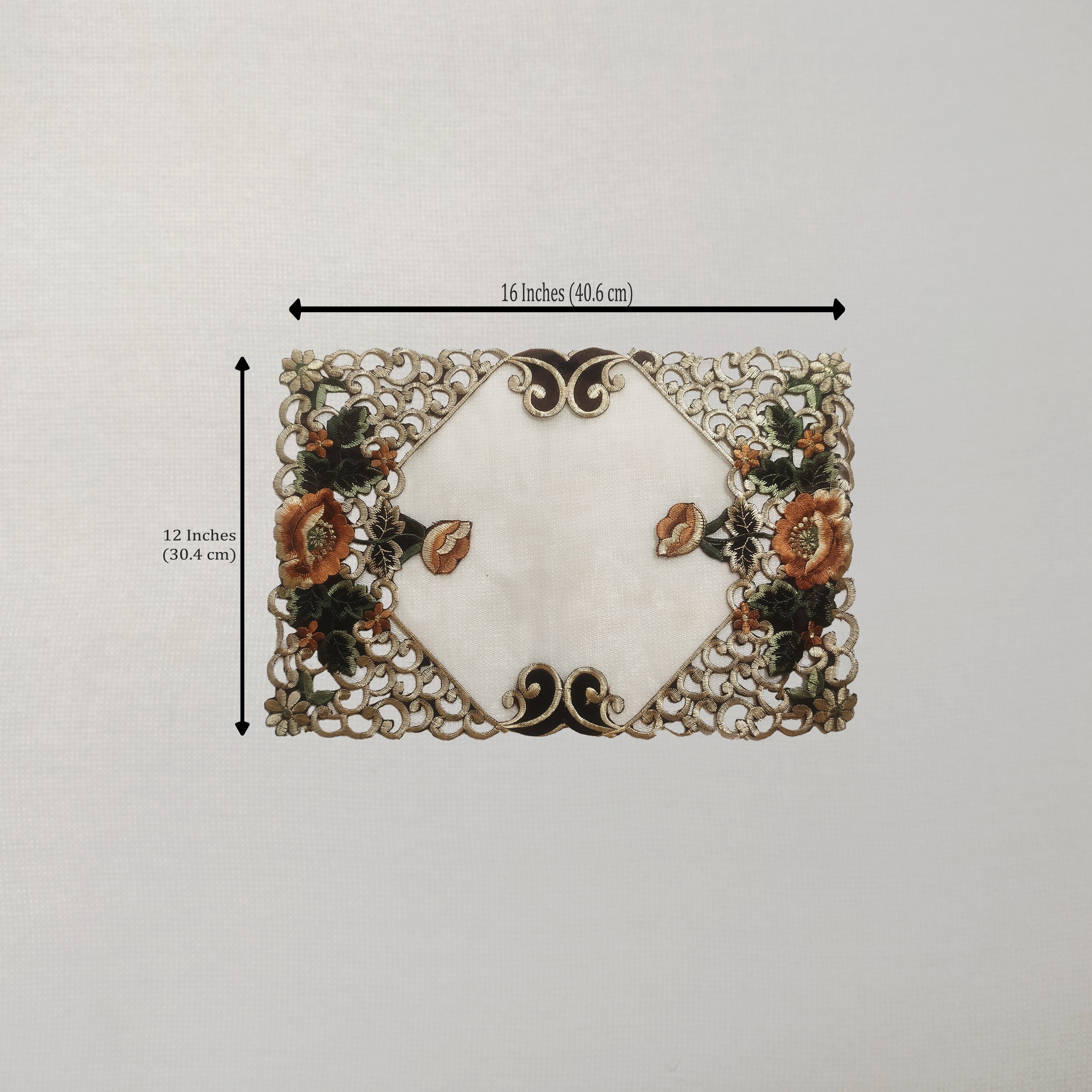 A rectangular placemat with a white center and ornate floral lace-like border, shown on a light neutral background with dimension arrows indicating 16 inches by 12 inches.