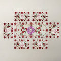 A set of six rectangular embroidered patches arranged in a cross-like layout on a light beige textured fabric background. The central patch is larger and features a purple floral motif, while the surrounding five patches are smaller and decorated with red and pink floral patterns, pink striped hearts, and green leaves.