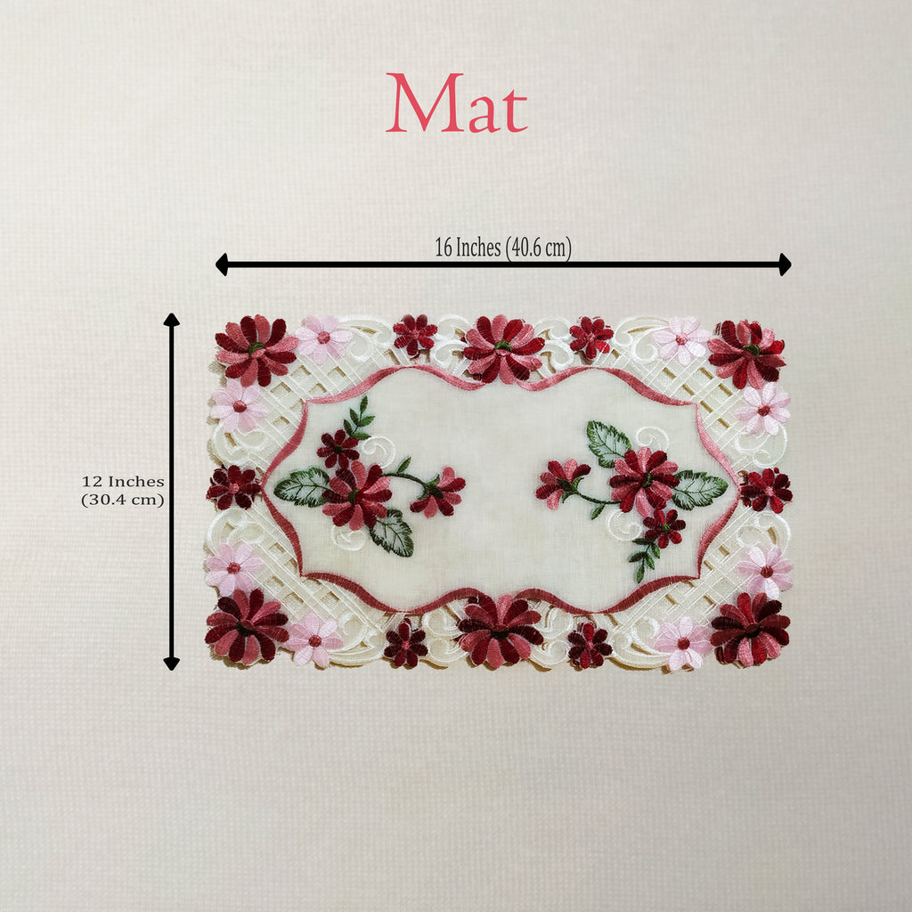 An embroidered floral mat shown on a light neutral background with dimension arrows and text indicating 16 inches by 12 inches.