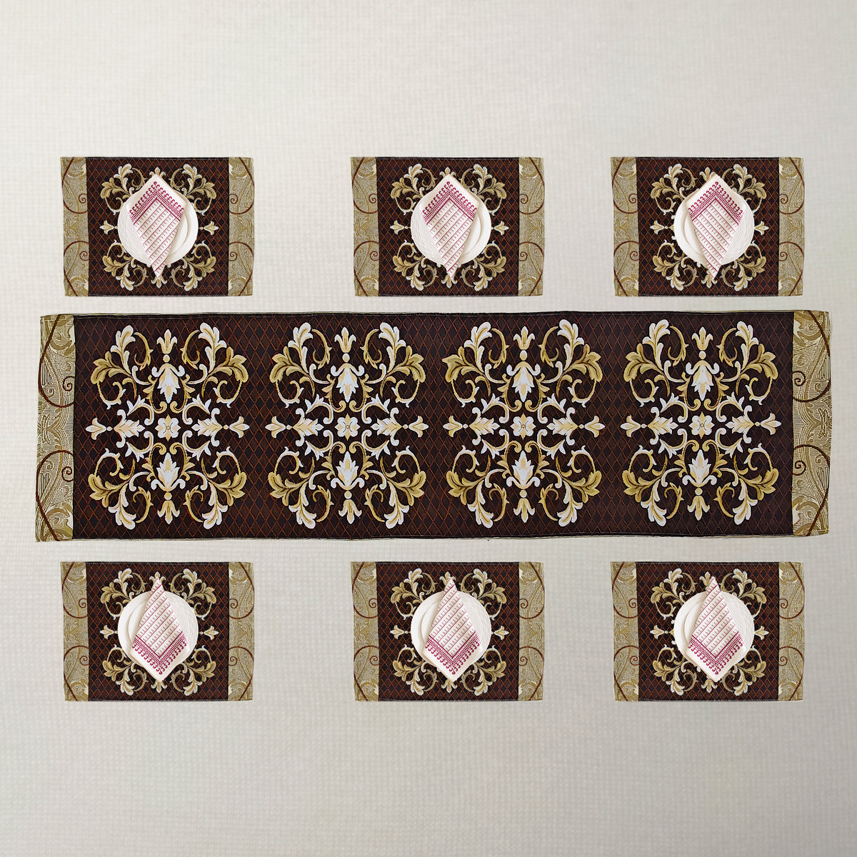 A set of table linens including a long runner and six placemats, featuring ornate gold and white baroque-style damask patterns.