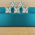 A modern teal-blue bench or sofa with five decorative cushion pillows featuring a geometric triangle pattern cushion cover in blue, gray, white, and brown, set against a beige wall and light wood floor.